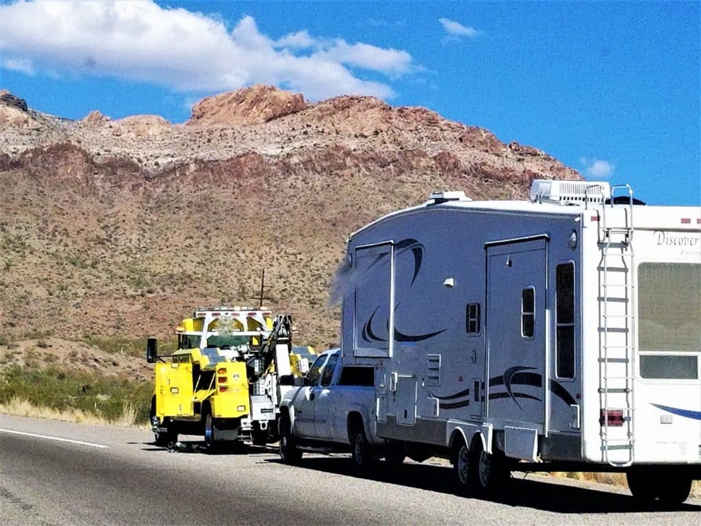 fifth wheel rv camper being towed by tow truck