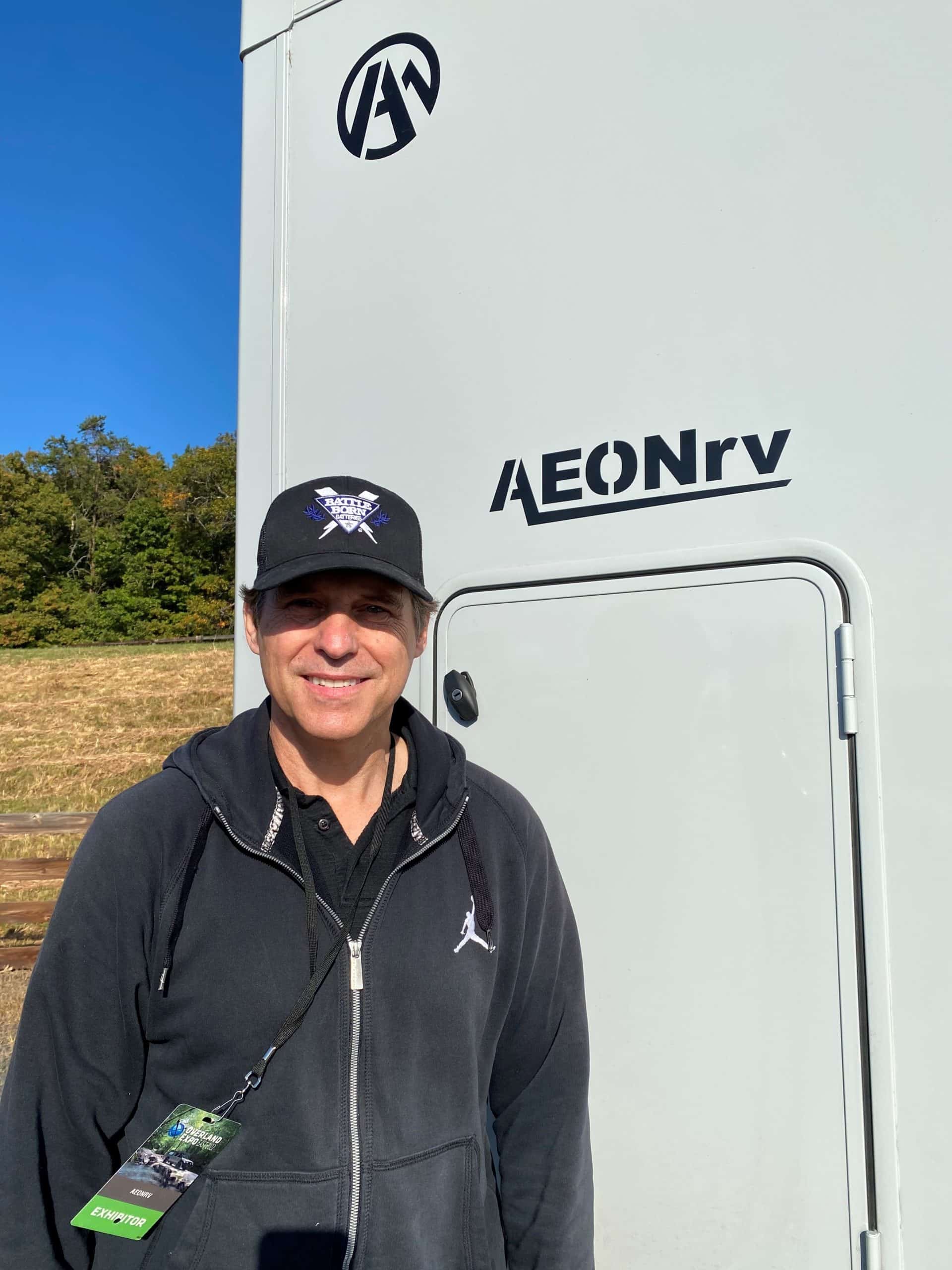 Jim Ritchie wearing a Battle Born Batteries hat smiling in front of his AEONrv