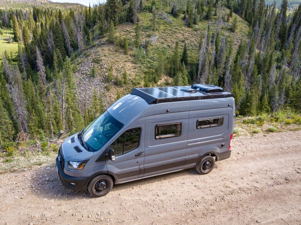 Van with solar panels on top parked off-road