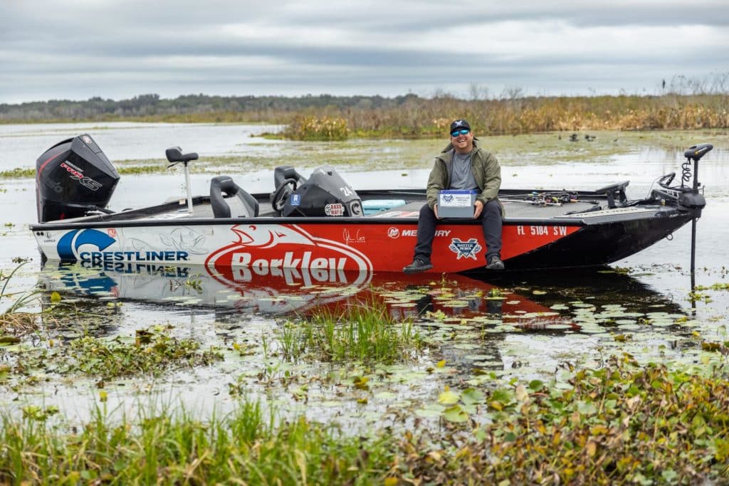 pro bass fisher sitting on boat with battle born lithium battery