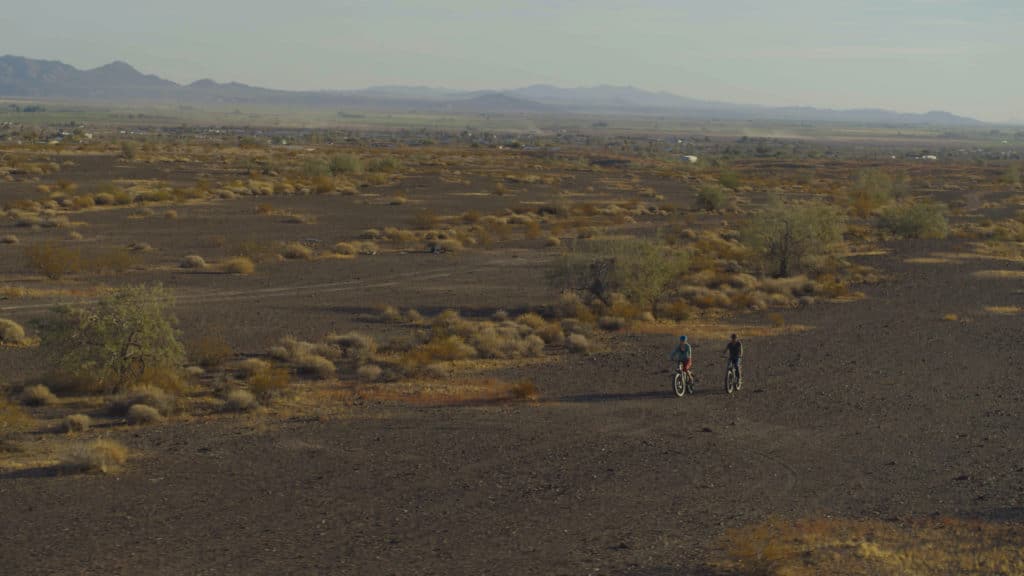 drone shot of a man and a woman biking in arizona desert