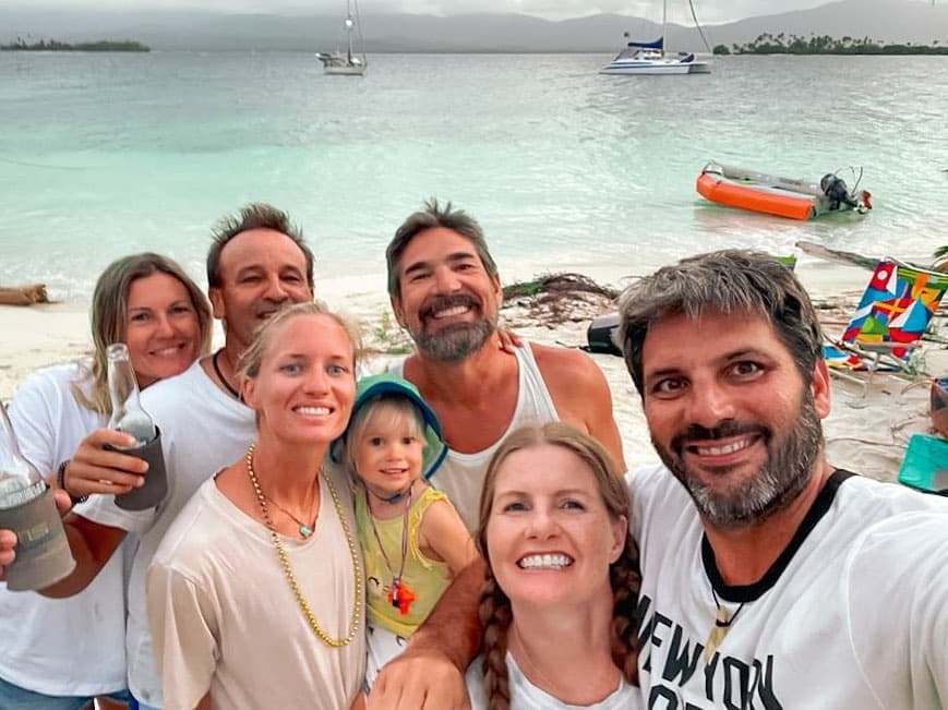 Calico Skies Sailing Bill and Grace with friends on the beach in a group selfie