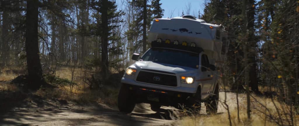 Toyota Tundra with a truck camper driving off-road