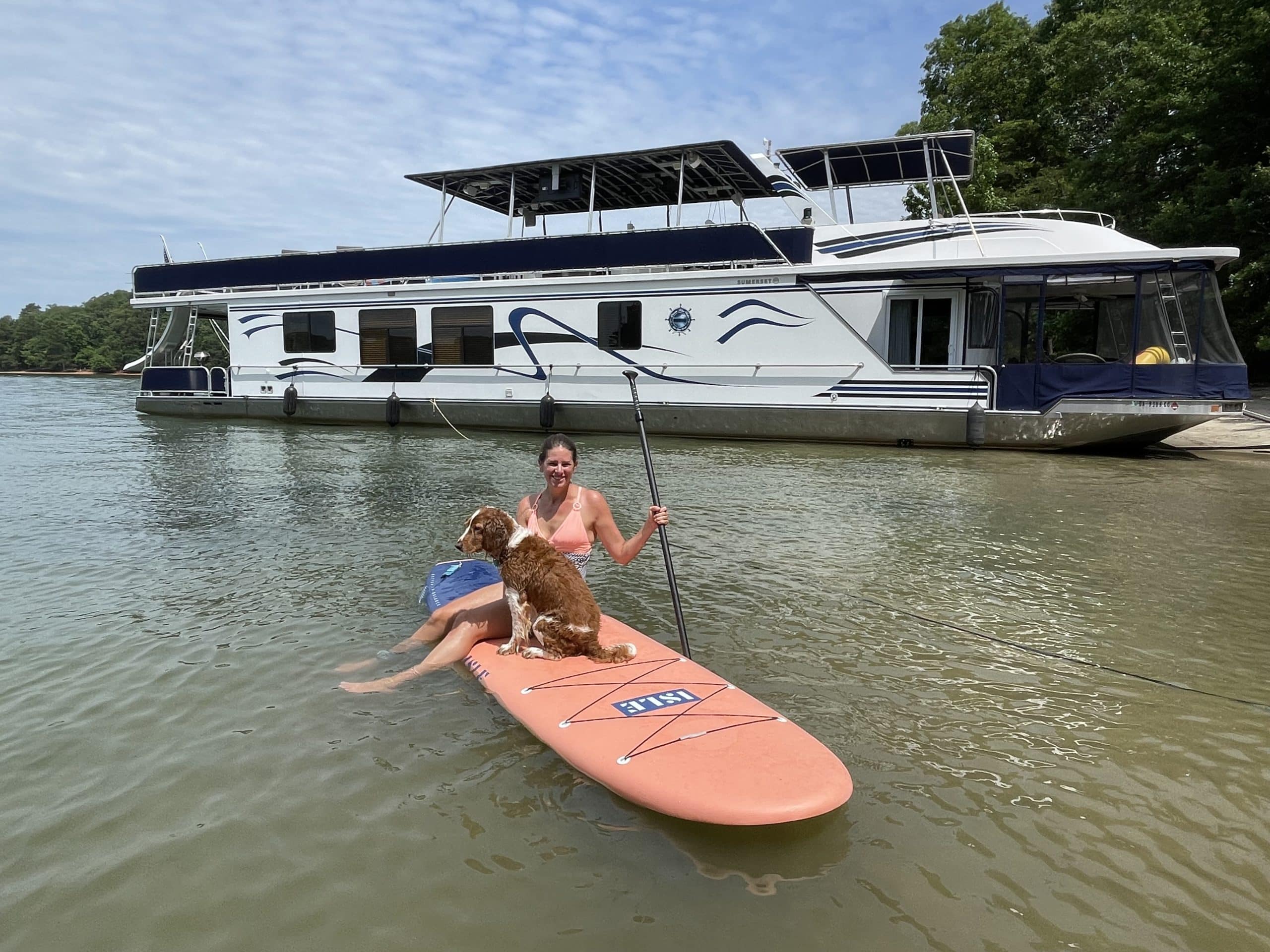 Jessie and Dory on a paddleboard next to their houseboat