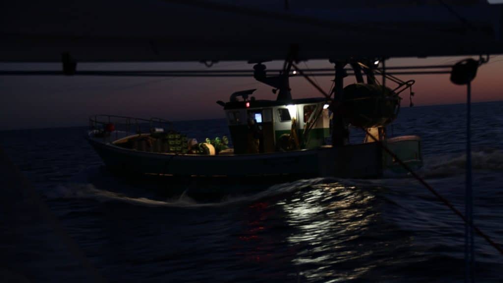 boat dimly lit on water in darkness