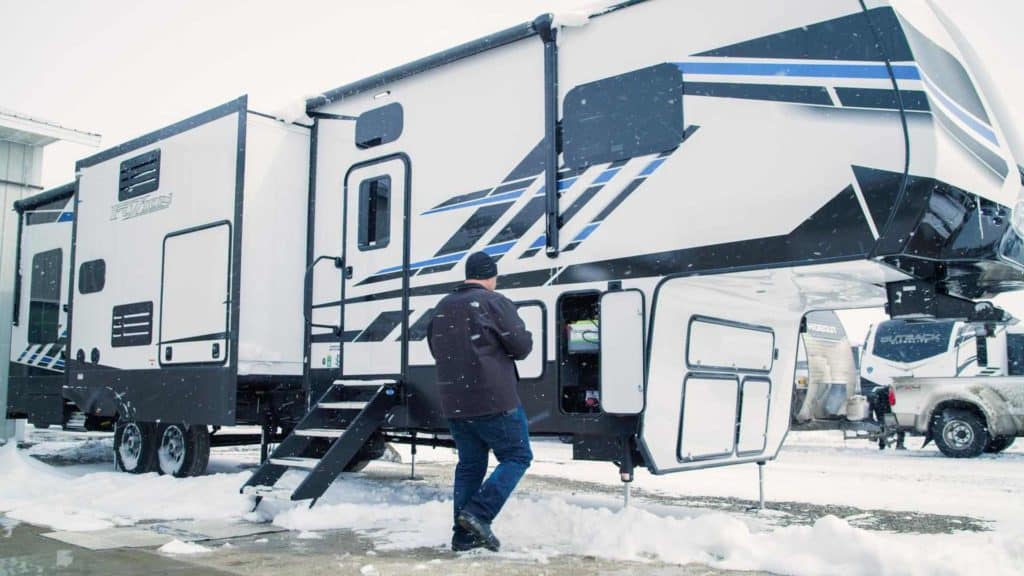 Rv with battery compartment open in a snowstorm