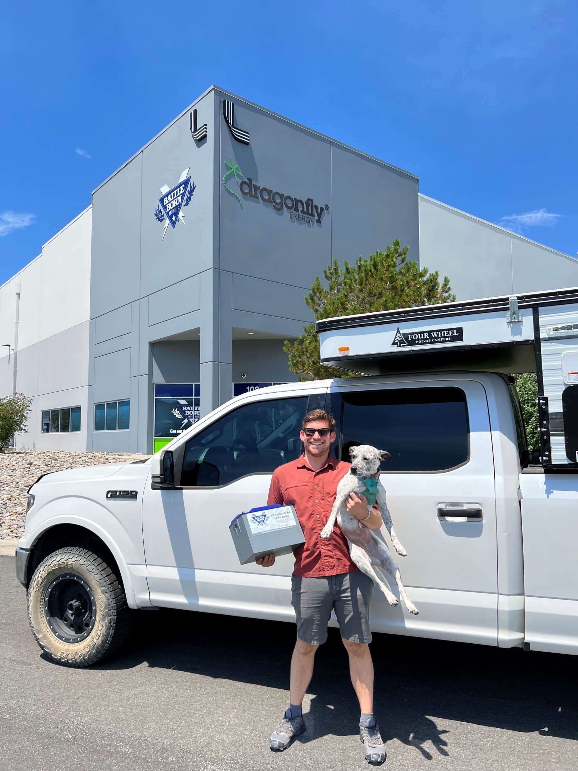 Stuart Palley with His Dog Holding a Battle Born Battery in Front of Headquarters