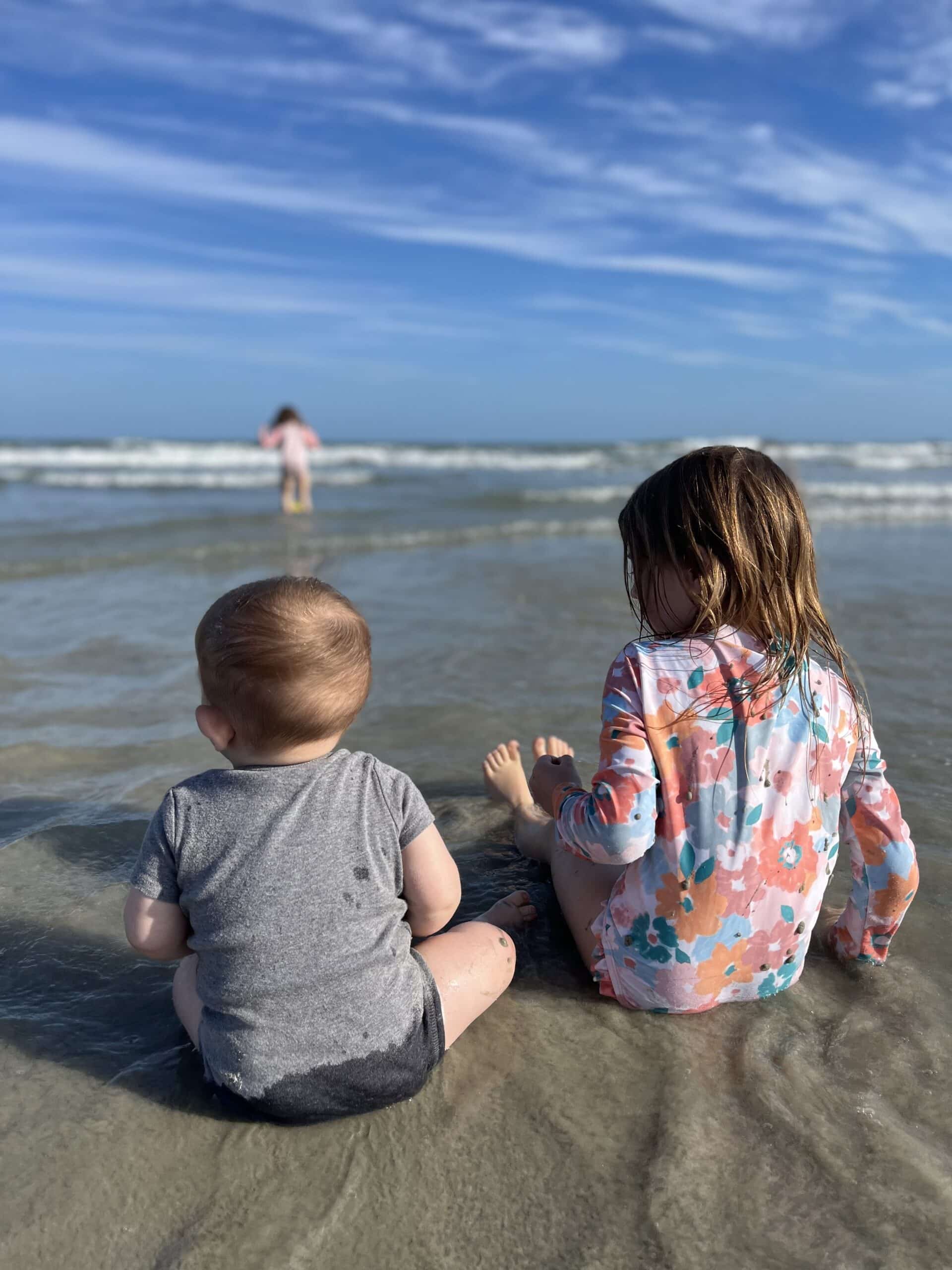 Siblings Sitting in the Sand at the Ocean