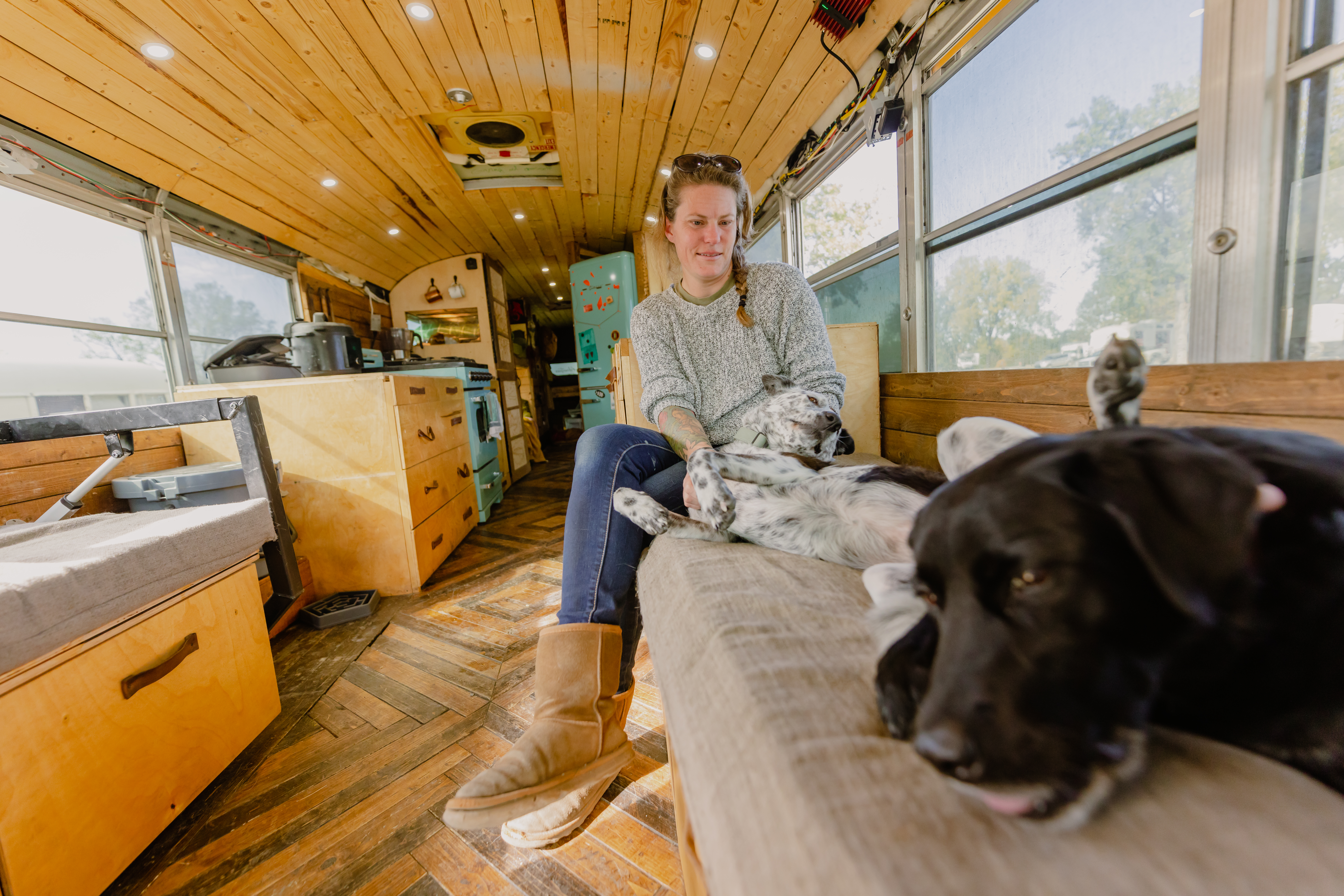 Jessica Rambo playing with her dogs inside of her converted skoolie