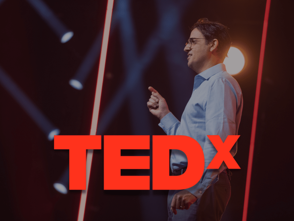TedX Logo over Denis Giving Tedx Talk
