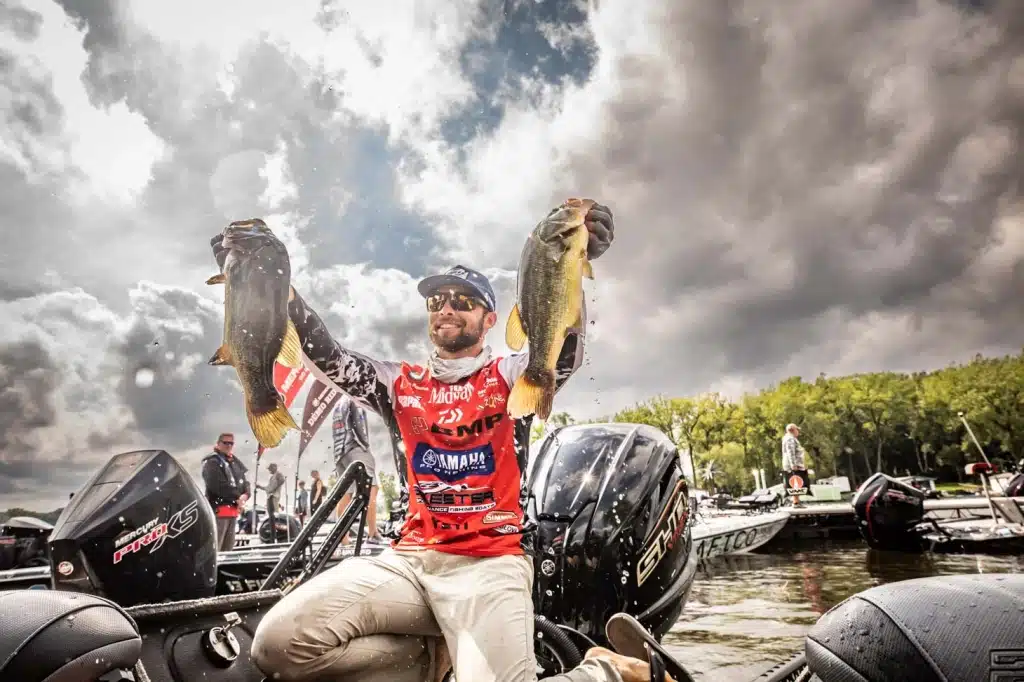 Contestant, Professional Angler Palaniuk holds up two bass fish at the Bassmaster Classic last year