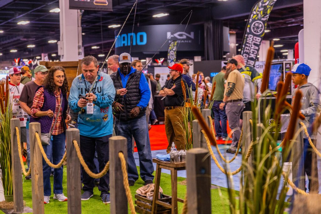 Attendees at the Bassmaster Classic 2022 try out different fishing poles during the outdoor expo.