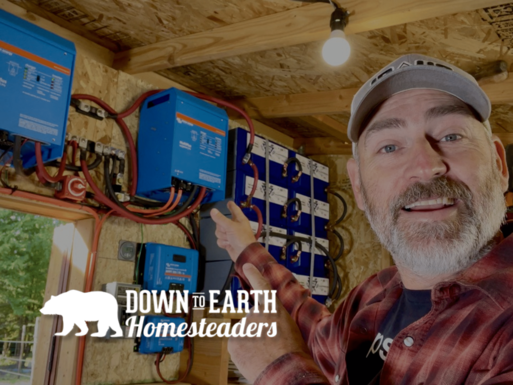 Down to Earth Homesteaders Logo Over Martin Johnson with Battle Born Batteries System