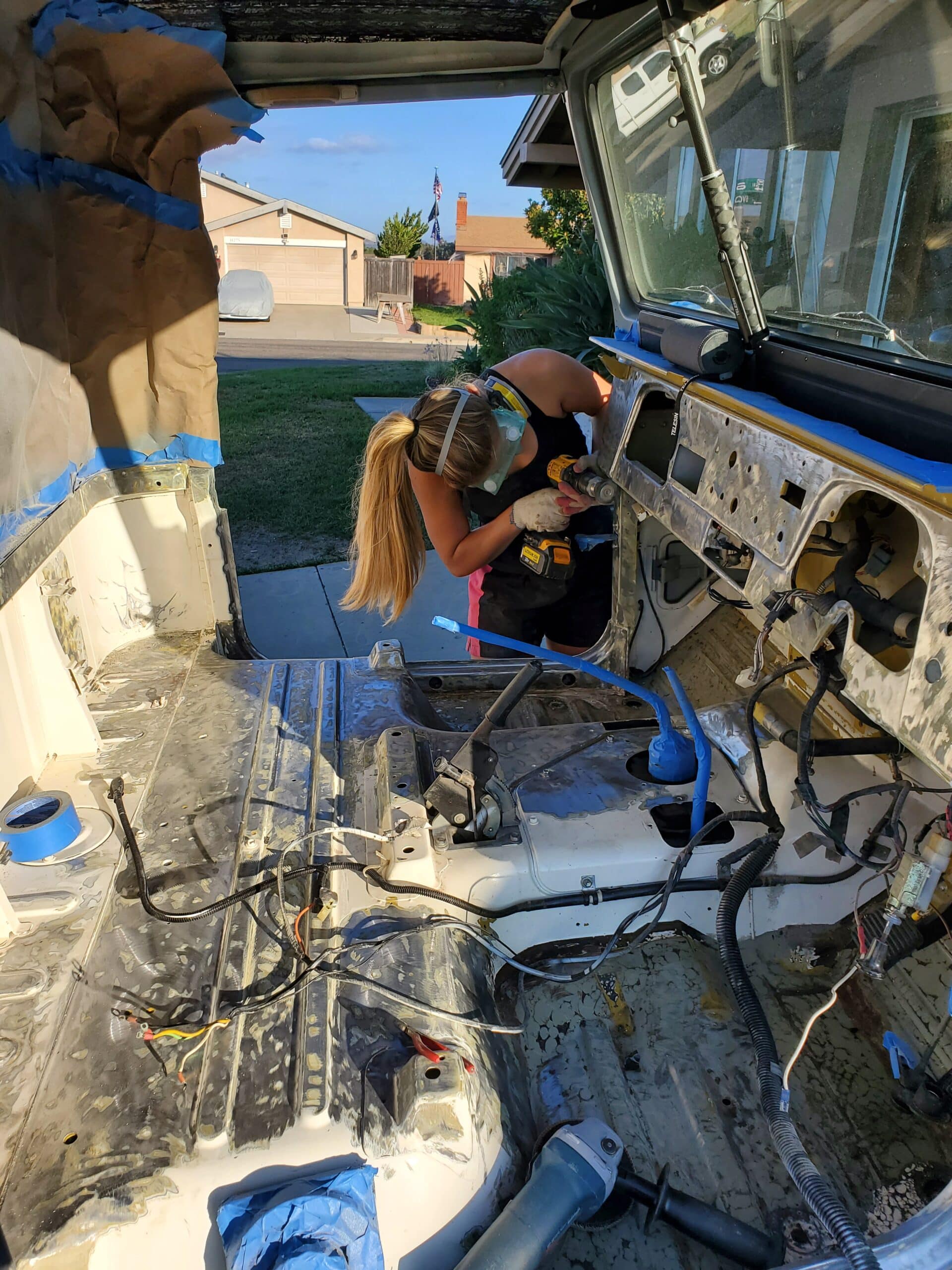 Lauren drilling something into the Land Cruiser during renovation