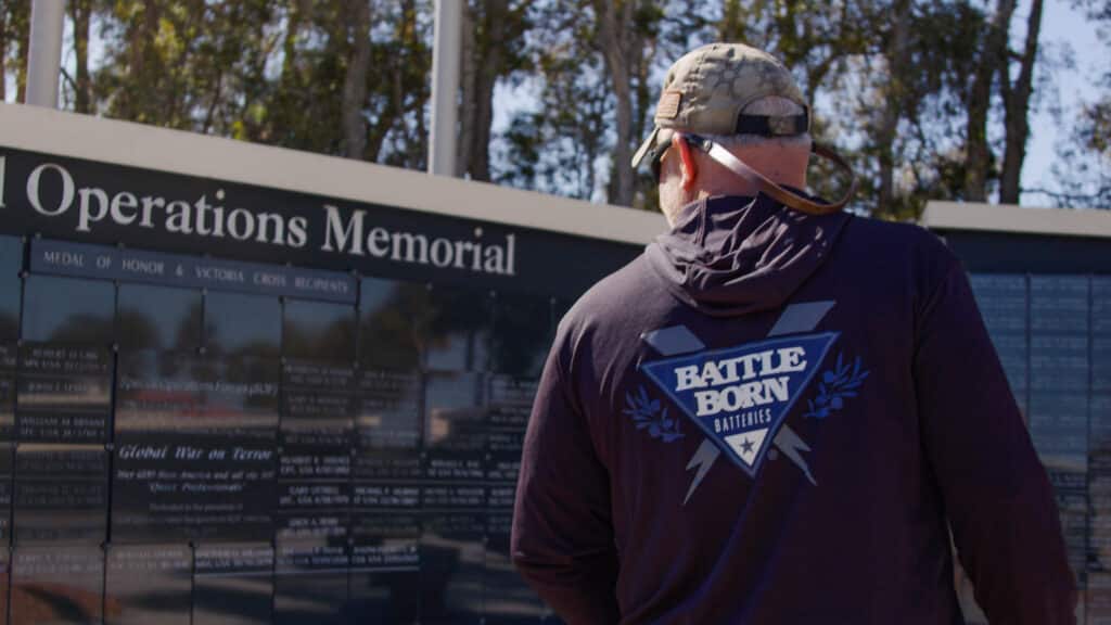 Adam Wygnanski in Battle Born Batteries Shirt at a Veteran's Memorial