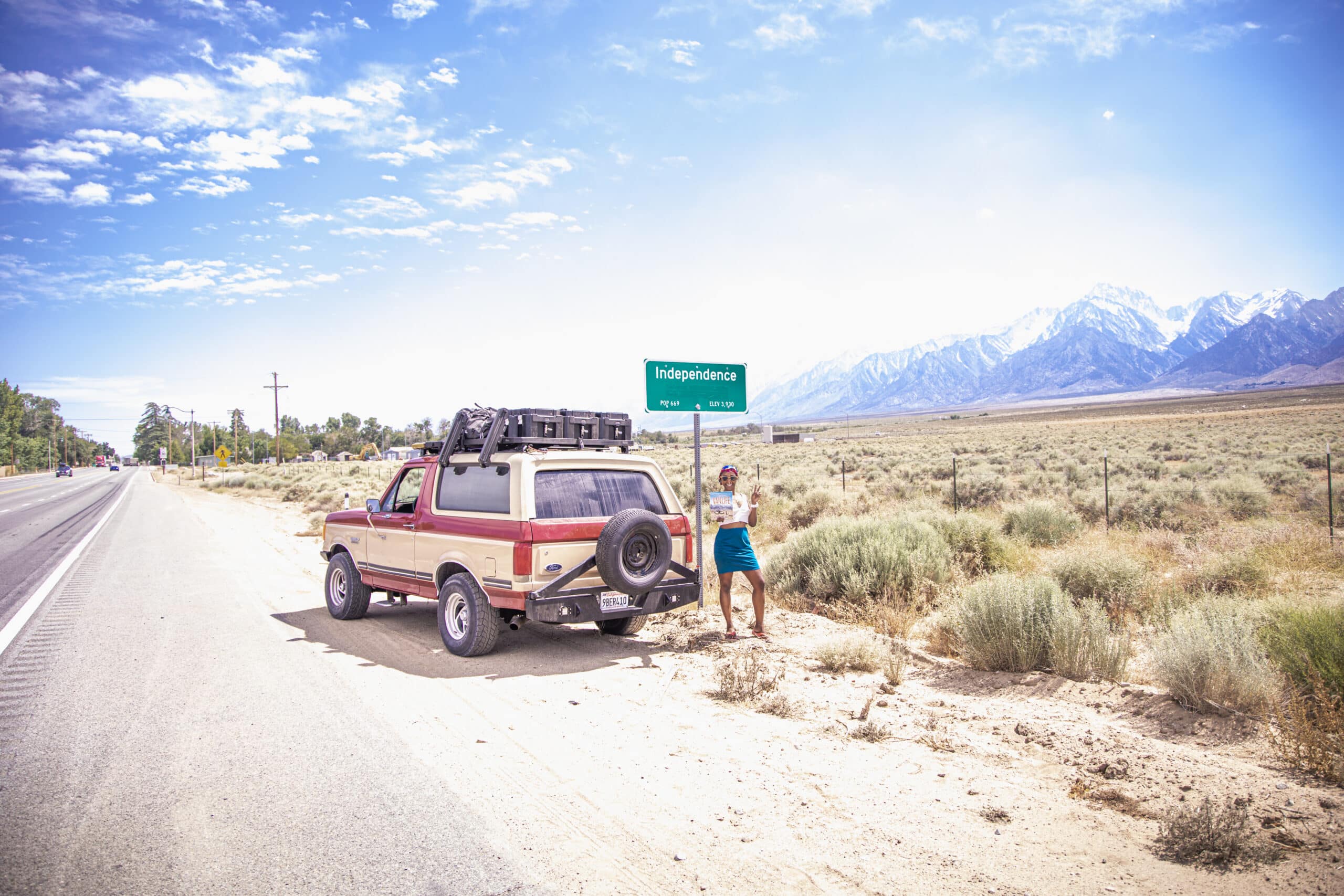 Irie to Aurora's Bronco parked in front of an "Independeca" sign on the side of a road