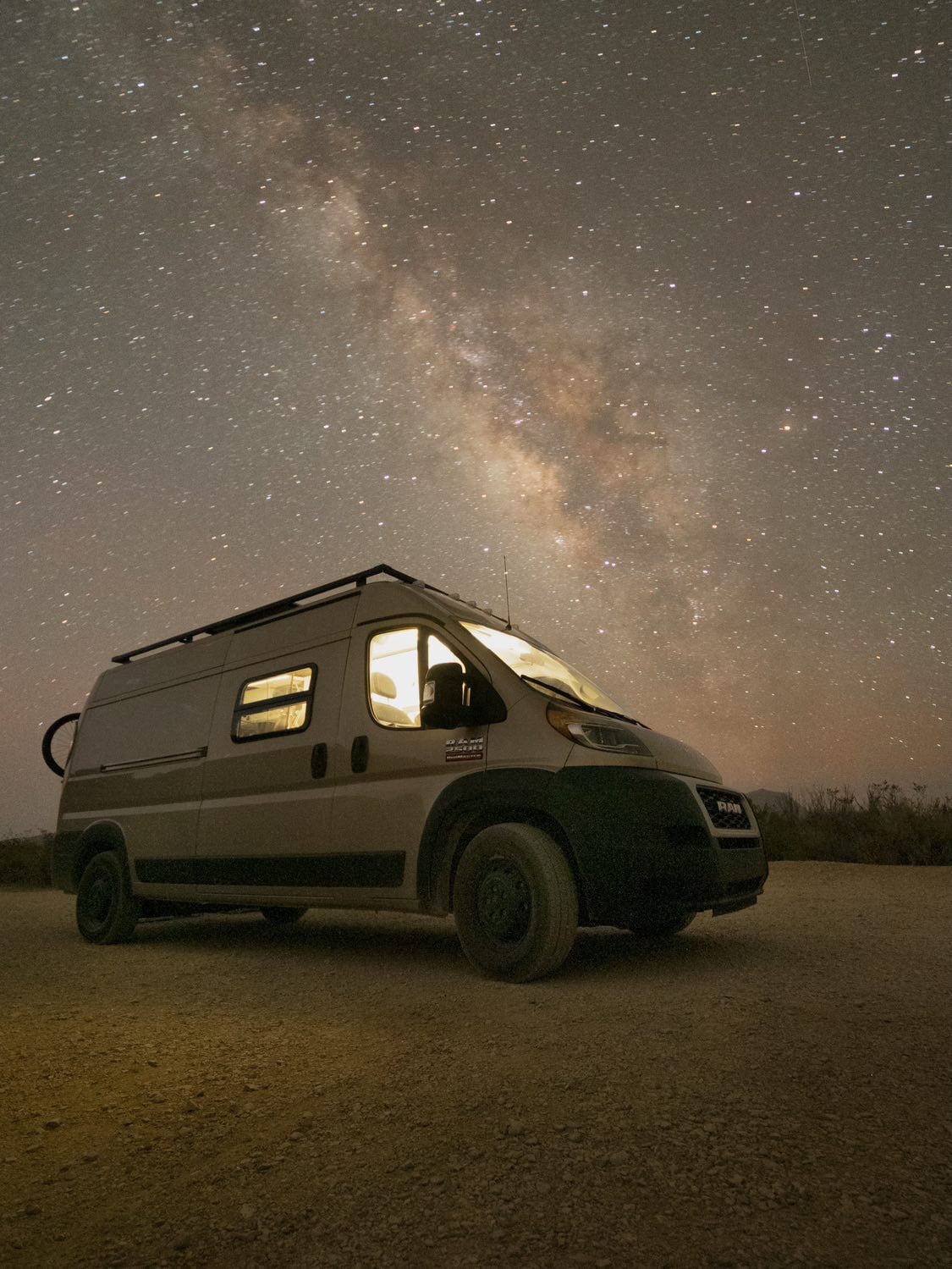 A Dodge Ram van is parked under a starry sky for boondocking