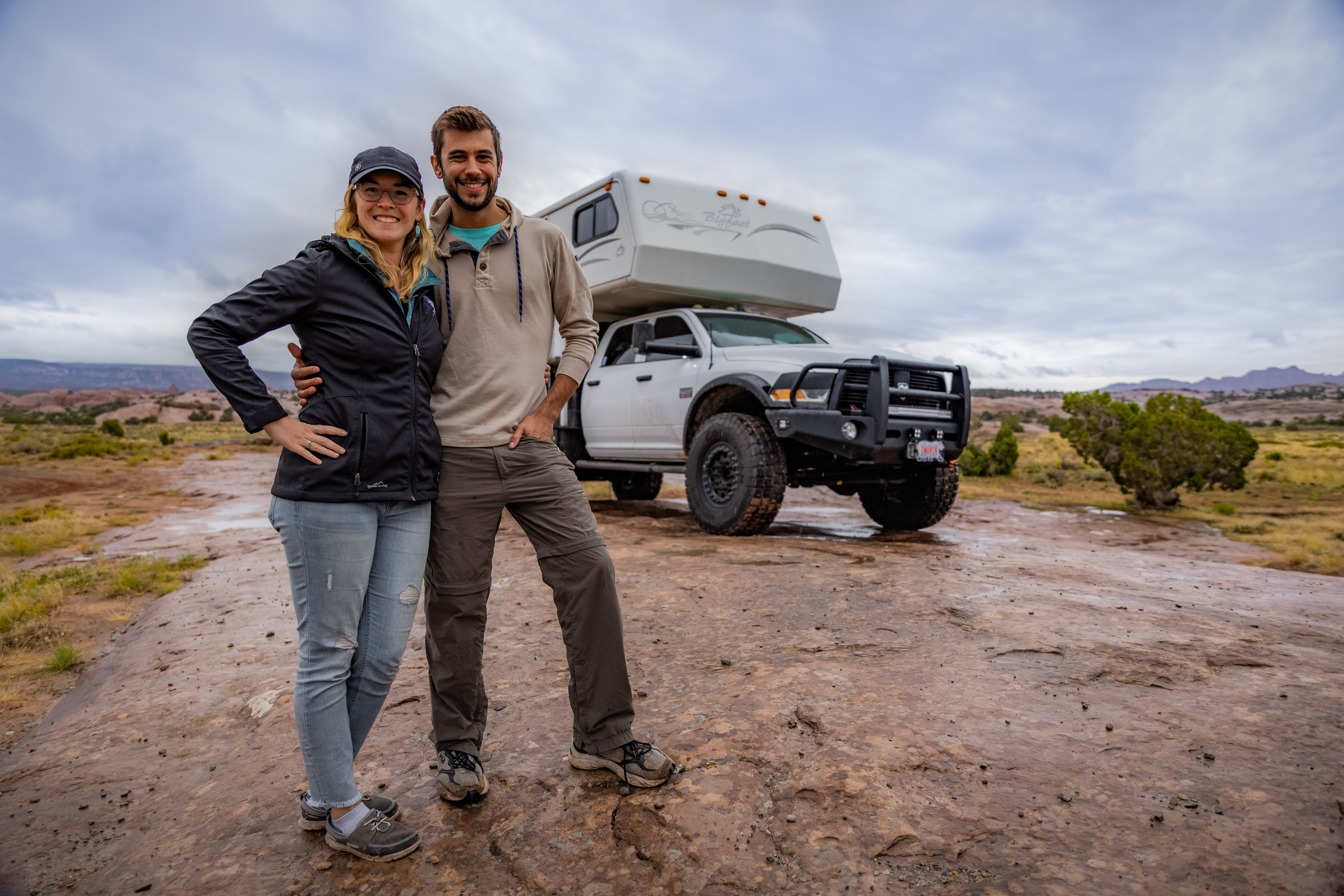 Tom and Caitlin Morton standing in front of their truck camper