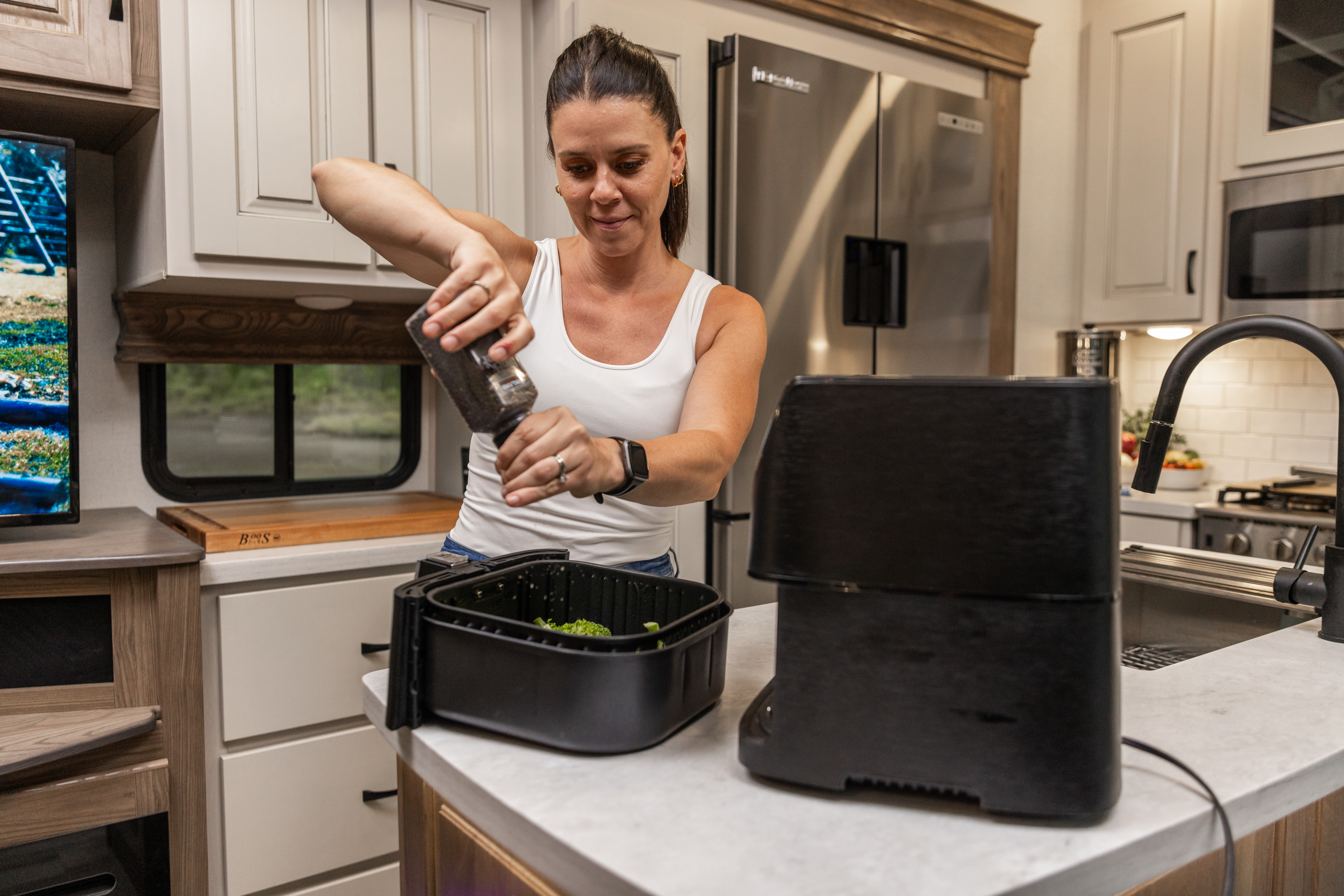 Woman cooking with an air fryer while boondocking in her RV