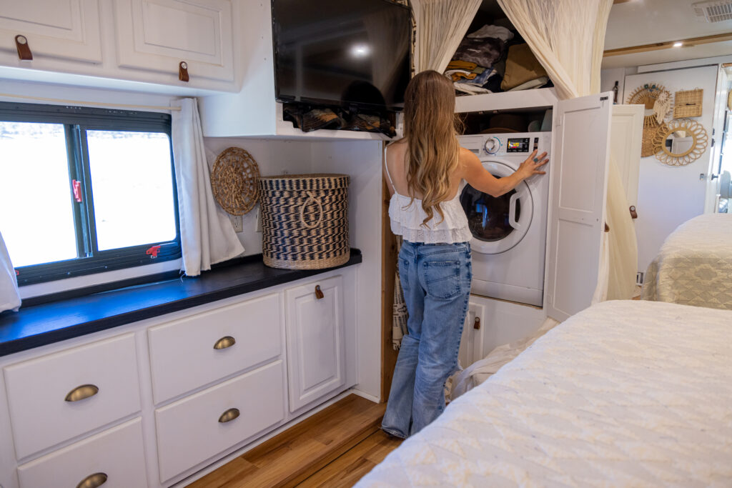 woman in RV running a washine machine off-grid on lithium batteries
